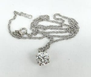 Silver necklace with a round diamond pendant.