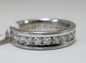Silver ring with embedded clear gemstones.
