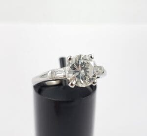 Diamond solitaire ring on black stand.