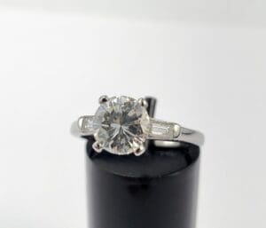 Diamond ring with baguette accents on display.