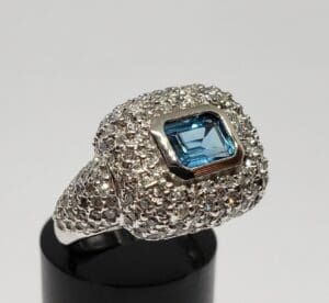 Silver ring with blue gemstone on display.