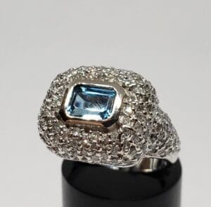 Silver ring with blue gemstone and diamonds.