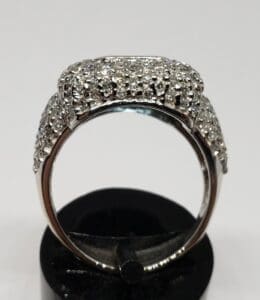 Diamond-encrusted ring on black stand.