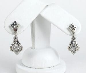 Silver earrings with diamond accents on display.