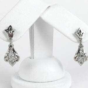 Silver earrings with diamond accents on display.