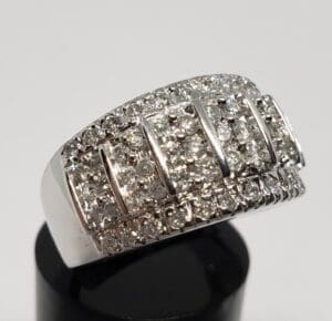 Diamond-studded silver ring on display stand.