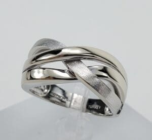 Silver intertwined design ring on display.
