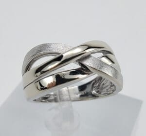 Silver intertwined band ring on display stand.