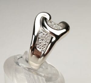 Silver ring with embedded small diamonds displayed.