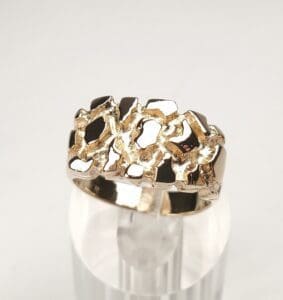 Gold ring with textured, abstract design.