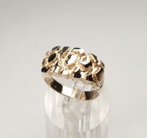 Gold textured ring on clear stand.
