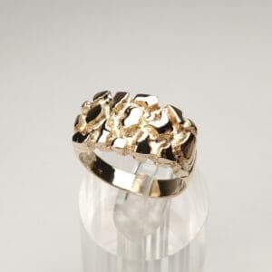 Gold textured ring on clear stand.