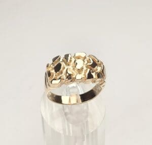 Gold ring with textured design on display.