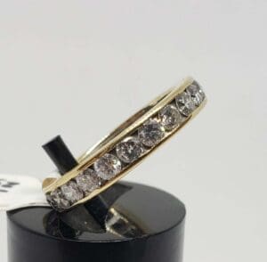 Gold ring with diamonds on display stand.