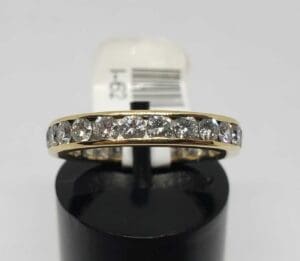 Gold ring with embedded clear gemstones.