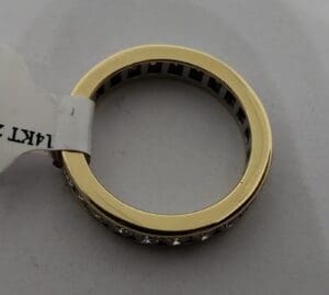 Gold ring with diamond accents on tag.