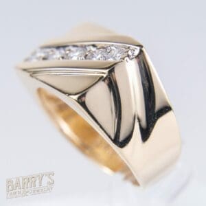 Gold ring with diamond accents, side view.