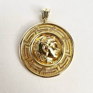 Gold medallion with engraved profile design.
