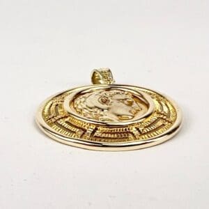 Gold pendant with embossed circular design.