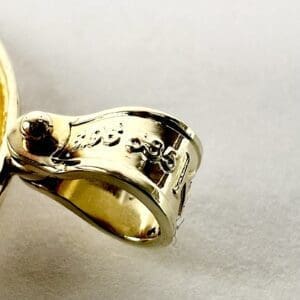 Golden zipper pull with engraved text detail.