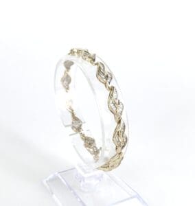 Gold bracelet with leaf design on display.