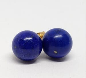 Two round blue earrings on white background.