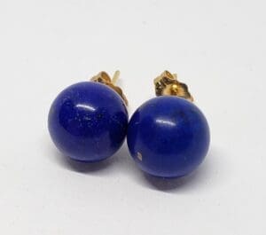 Blue spherical earrings on white background.