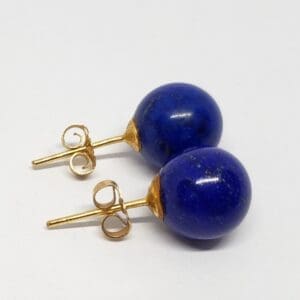 Gold earrings with round blue stones.