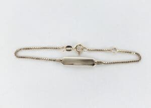 Gold bracelet with a rectangular plate.