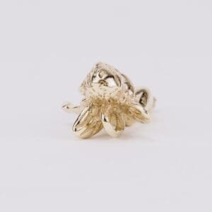 Gold octopus-shaped ring on white background.