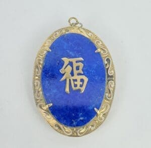 Blue pendant with gold Chinese character.