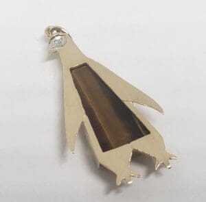 Penguin-shaped pendant with gemstone inlay.