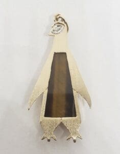Penguin-shaped pendant with gemstone inlay.