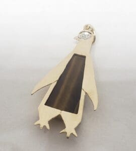 Gold penguin-shaped pendant with gemstone.