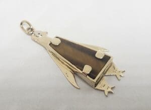 Gold penguin pendant with gemstone body.