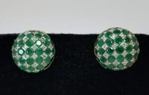 Green gemstone circular earrings on display.