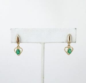 Gold heart earrings with green stones.