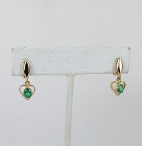 Gold heart earrings with green stones.