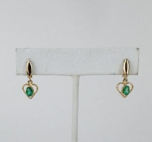 Gold earrings with green gemstone hearts.