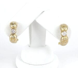 Gold earrings with diamond accents on display.