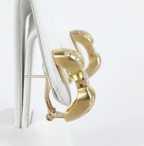 Gold hoop earrings with small diamonds.