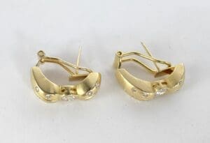 Gold earrings with small diamond accents.