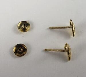 Gold screw-back earrings and backs on display.