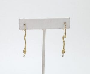 Gold dangling earrings with small gemstones.