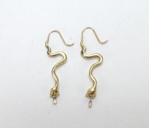 Gold snake earrings with dangling crystals.