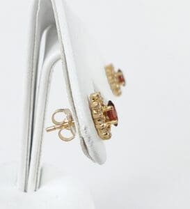 Gold earrings with red gemstones on display.