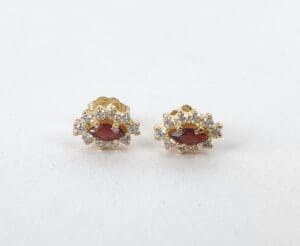 Gold earrings with red gemstones and diamonds.