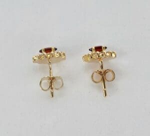 Gold earrings with red gemstones.