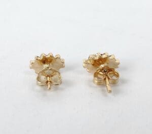 Gold flower-shaped stud earrings on display.