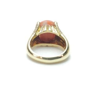 Gold ring with red gemstone and diamonds.